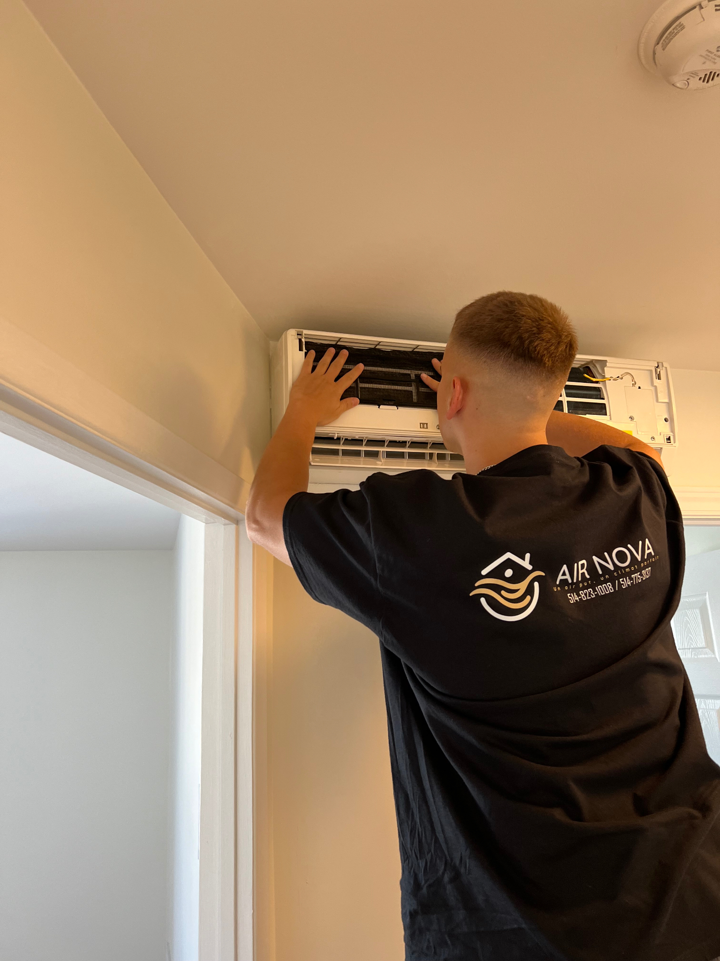 Technicien Air Nova nettoyant une thermopompe murale en résidence